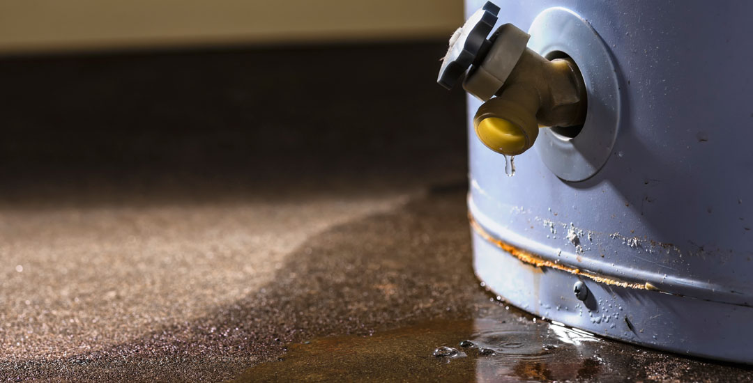 leaking water heater - puddle on floor from water heater leaking|
