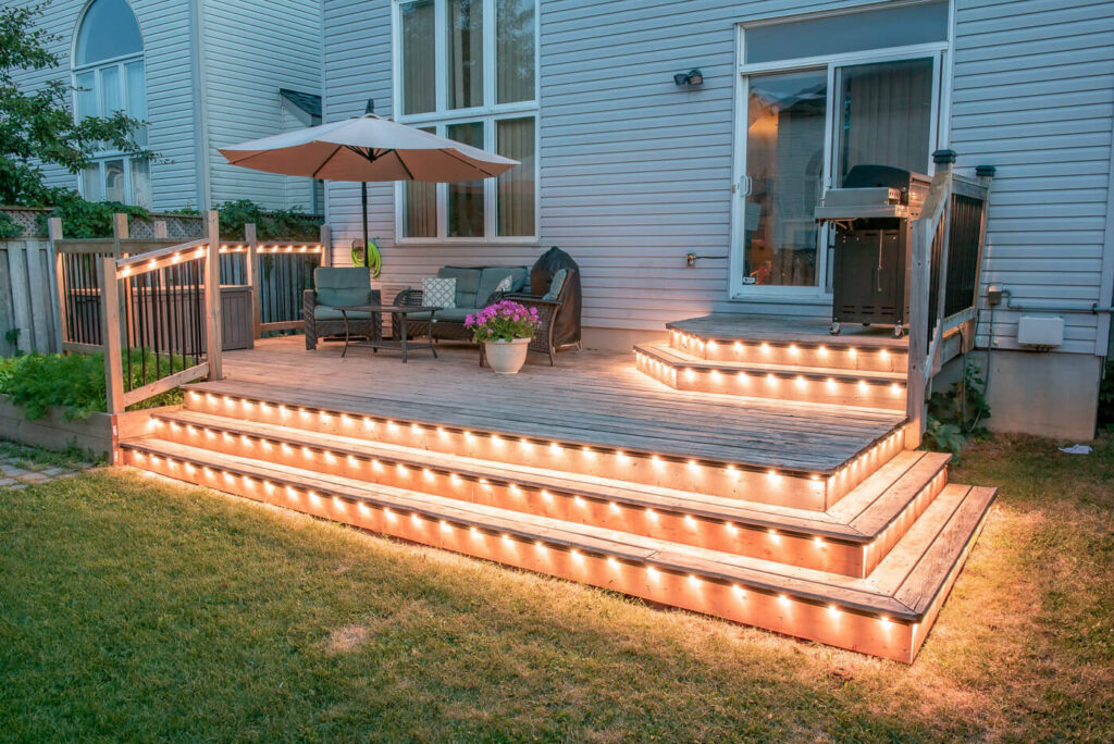 Backyard deck and stairs lit with permanent outdoor lighting