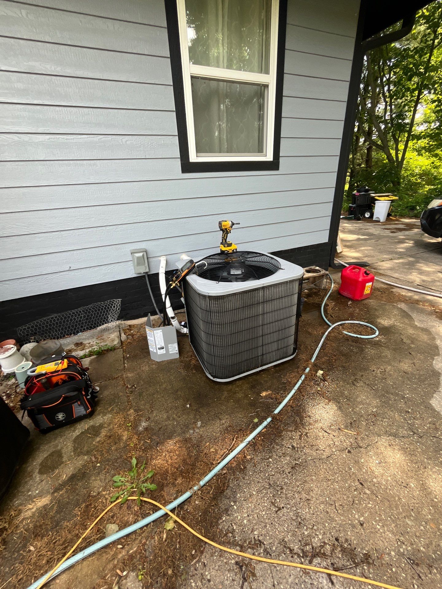 Paschal technician Casey servicing an open outdoor AC condenser during a tune-up in St. Joseph, MO